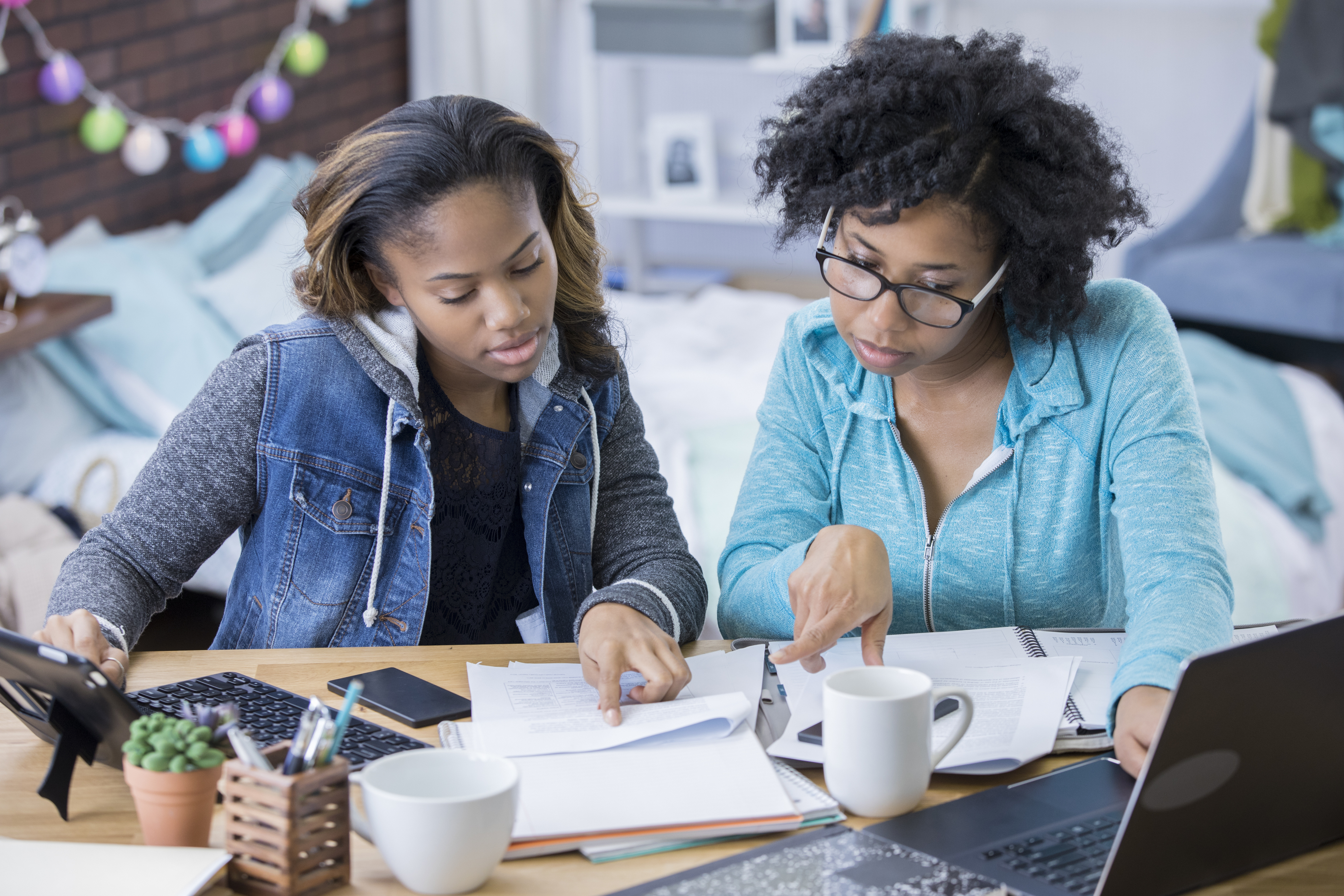 mom and teen daughter reviewing financial documents