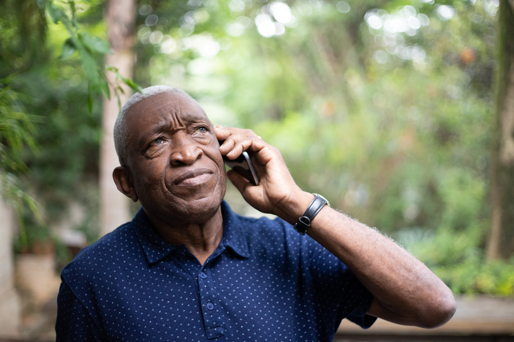 older african american male listening to mobile phone with expression of concern