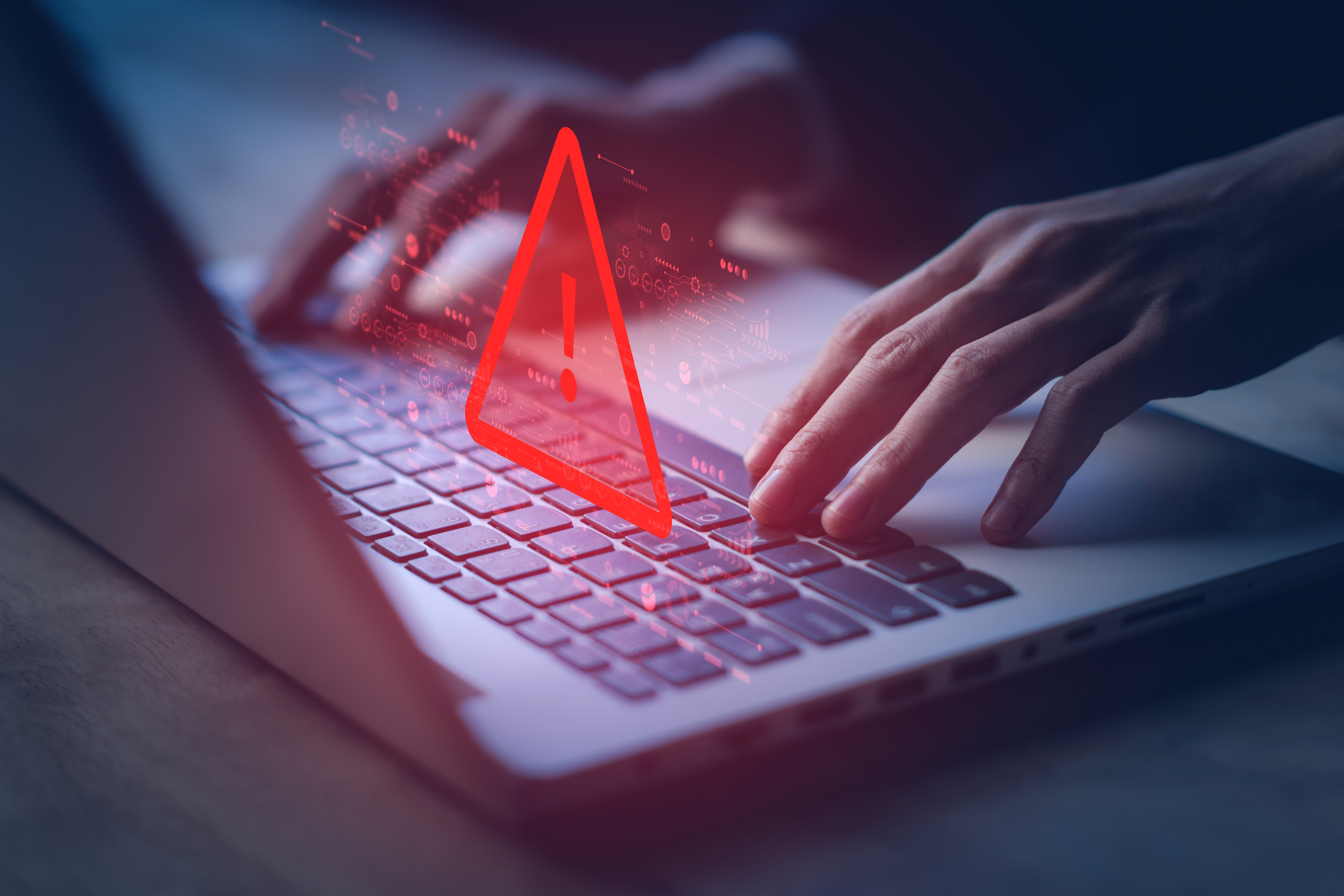 hands on laptop with red alert exclamation point floating above keyboard