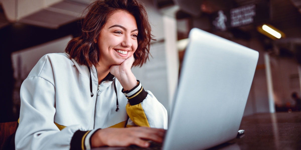girl smiling at laptop graphic