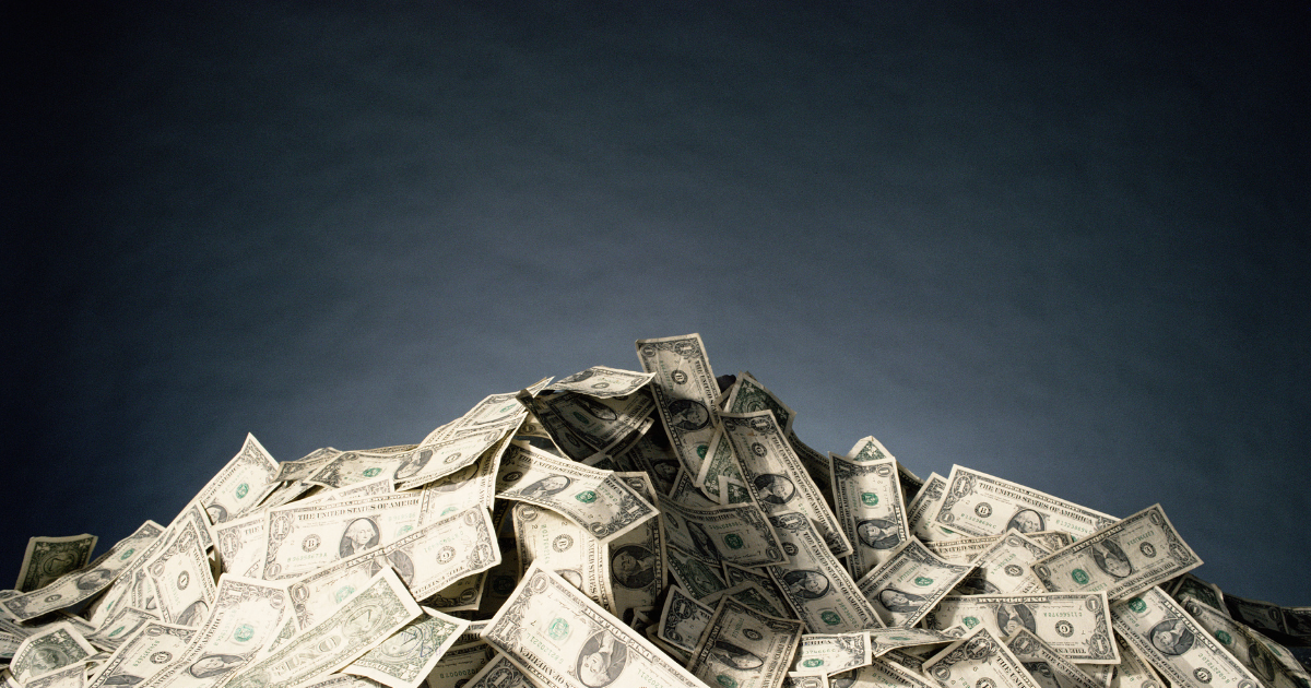 big pile of money in front of dark background