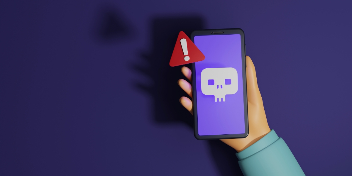 hand holding phone with red alert and scam emoji on screen