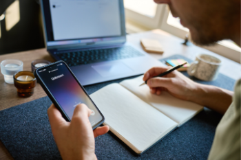 unknown caller calling man on phone writing in notebook Banner