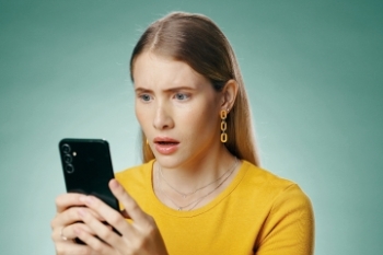 younger woman looking surprised at her phone Banner