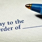 Check "pay to the order of" blank field with ink pen