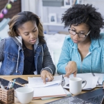 mom and teen daughter reviewing financial documents
