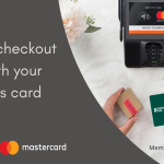 Hand holding a Traditional Bank debit card at the payment counter ready to use a card reader