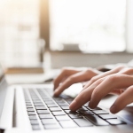 hands typing on laptop keyboard