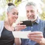 older couple taking a picture of check on phone