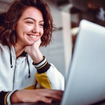 girl smiling at laptop graphic