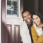 happy mixed couple in front door
