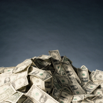 big pile of money in front of dark background